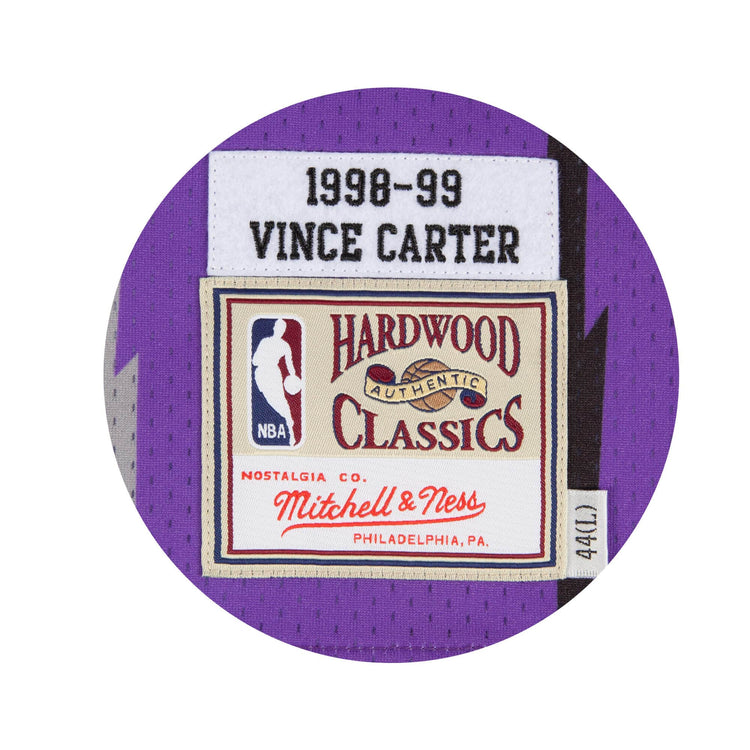 Canotta Mitchell & Ness NBA Vince Carter 1998 Raptors viola, dettaglio tessuto e logo, stile swingman, maglia sportiva.
