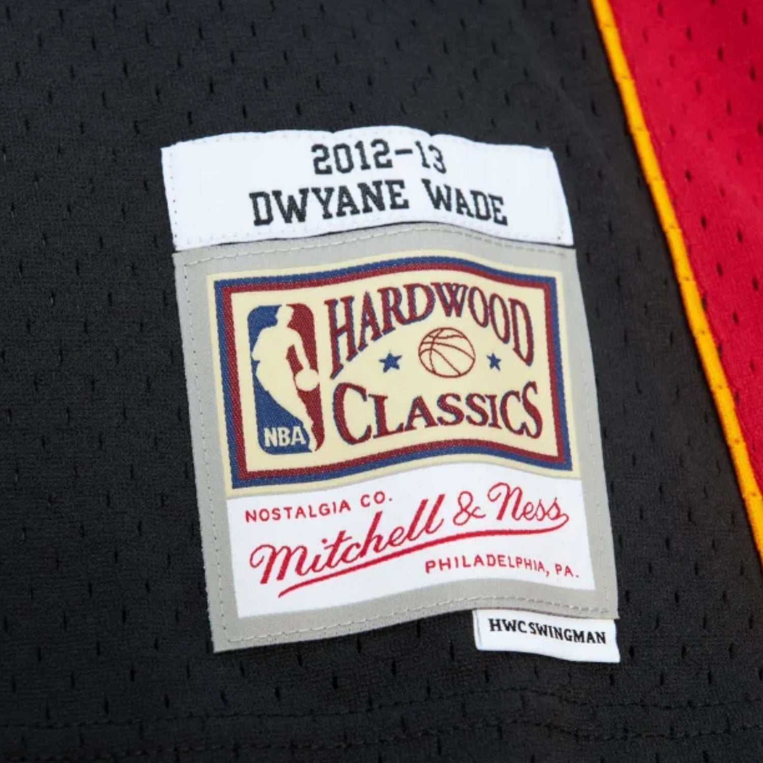 Canotta Mitchell & Ness NBA Heat 2012 Dwyane Wade nera, maglietta sportiva con logo e dettagli in bianco e nero.