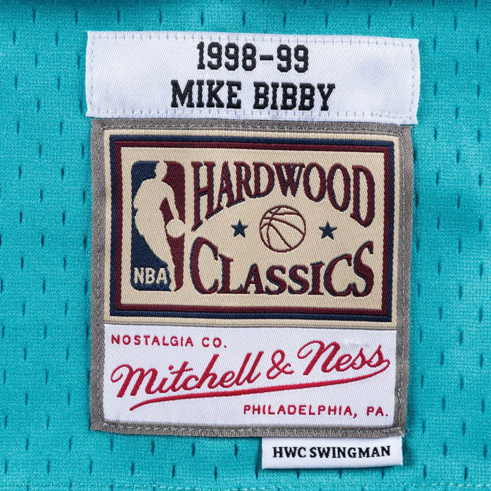 Canotta NBA Mitchell &Ness Mike Bibby Vancouver Grizzlies 1998-99 in teal, con dettagli del logo e design sportivo.