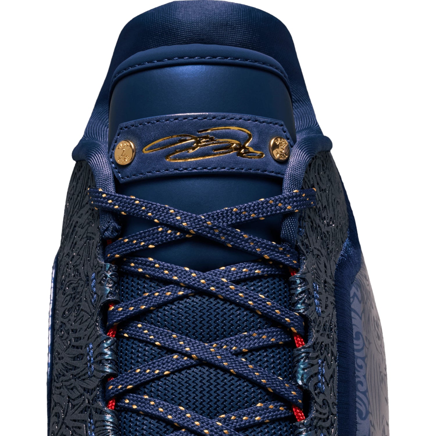 Scarpe da basket Nike LeBron XXIII "Out for Redemption" con dettagli in oro e blu, firma di LeBron James, su pavimento da palestra
